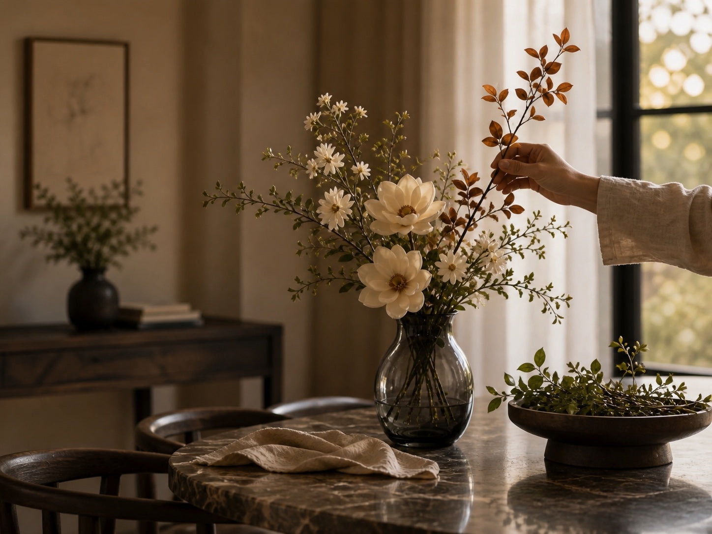 One muted seasonal branch being added to an existing ivory arrangement